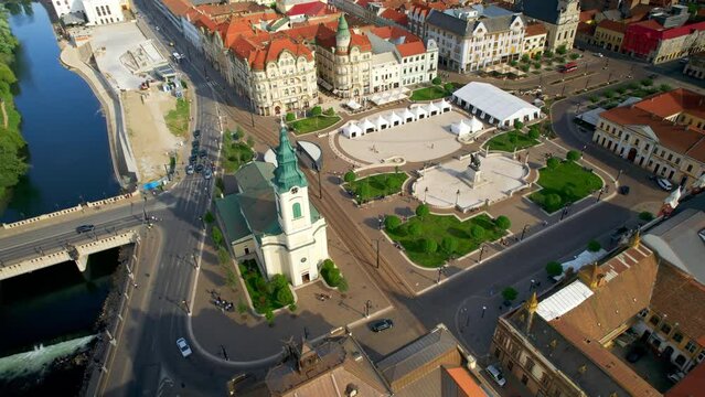 Areal drone view of the Unirii Square in Oradea downtown, Romania. King Ferdinand I statue, Saint Ladislaus Church and other historical buildings, walking people