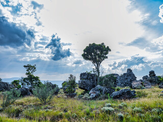 Wild grassfield, rocks and sun behind the cloud on Panorama Route, Mpumalanga, South Africa