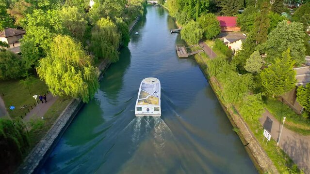 TIMISOARA, ROMANIA - MAY, 2023: Aerial drone view of Bega river with floating boat and greenery on the both sides of the river