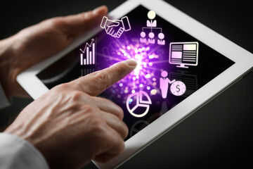 Marketing. Man using tablet against black background, closeup. Virtual icons popping out from device screen