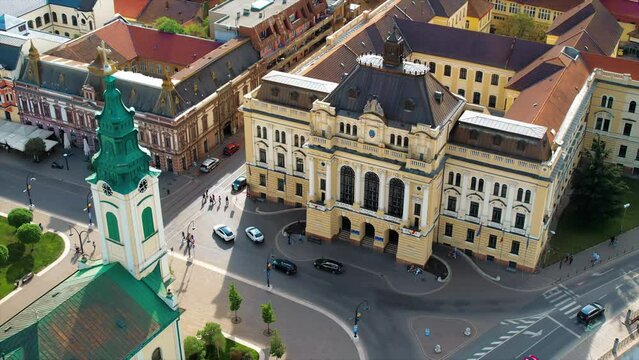 Areal drone view of the Unirii Square in Oradea downtown, Romania. Saint Ladislaus Church and Town Hall, walking people