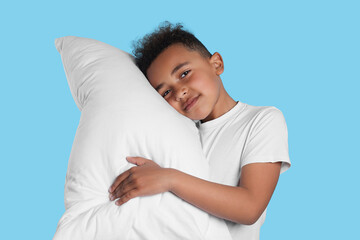 Boy with pillow on light blue background. Insomnia problem