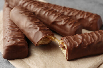 Sweet tasty chocolate bars with caramel on grey table, closeup