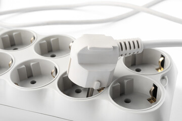 Power strip on white background, closeup. Electrician's equipment