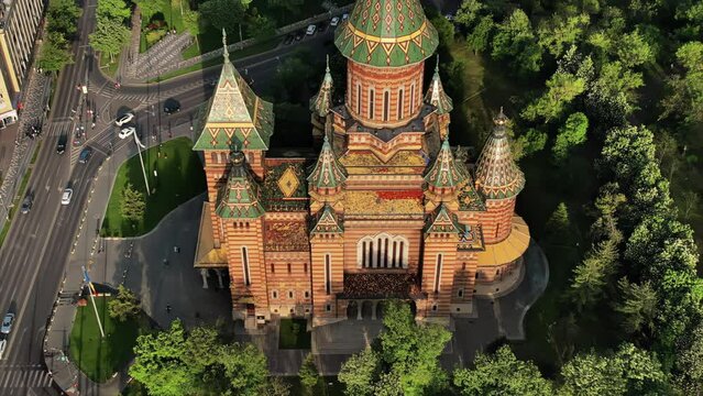 Aerial drone view of the Orthodox Cathedral facade with historical buildings and greenery around in Timisoara, Romania