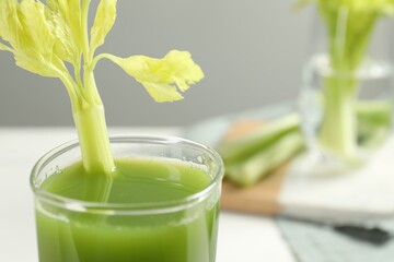 Glass of fresh celery juice against blurred background, closeup. Space for text
