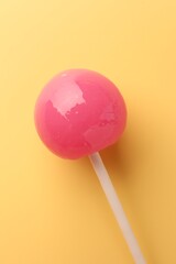 One tasty lollipop on yellow background, top view