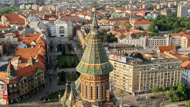 Aerial drone view of the Orthodox Cathedral dome with historical buildings and greenery around in Timisoara, Romania