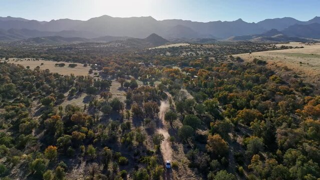 Drone shot of car driving towards camera in Willcox, Arizona, wide revealing shot