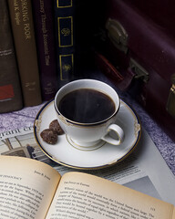 本と新聞の上のコーヒーカップに入ったおいしいコーヒーを飲んで楽しい時間を過ごすコーヒータイム