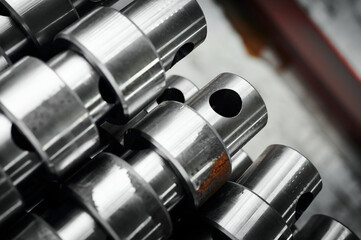 Stacks of steel rollers with holes in plant warehouse