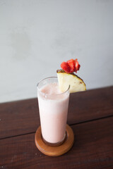 Strawberry Smoothie with sliced pineapple and starberry on the top. Selective focus and blurry