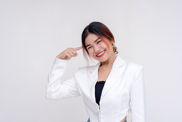 A cheerful young lady pointing to her brain while looking at the camera. Isolated on a white background.