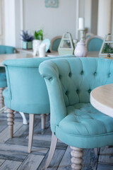 A blue armchair at an empty table in a Provence cafe.