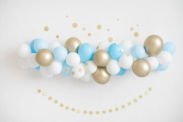 Garland of white, blue and gold balloons. Decor for baby shower.