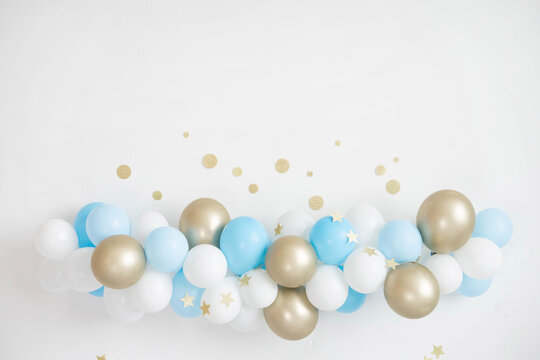 Garland of white, blue and gold balloons. Decor for baby shower.