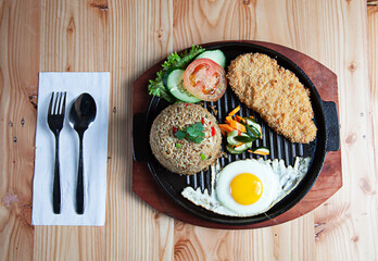 Fried Rice with Chicken. Prepared and served in a Plate. Natural wood in the background. Top view.