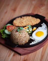 Fried Rice with Chicken. Prepared and served in a Plate. Natural wood in the background