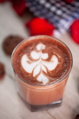 Hot Chocolate drink with latte art on wooden table and roses decoration