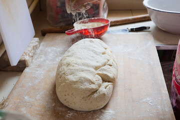 hand sprinkling flour on raw dough.