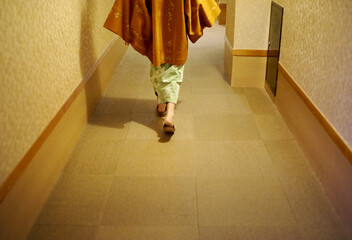 旅館の廊下を歩く浴衣姿の女性