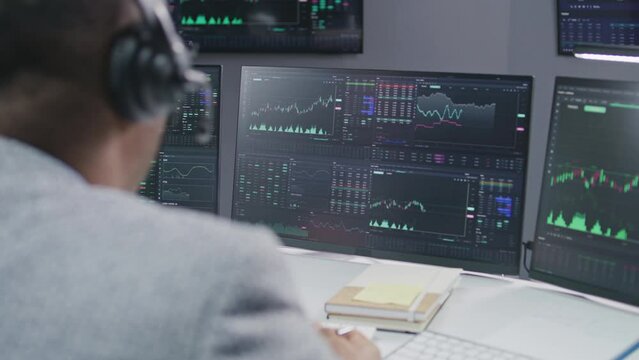 African American stock trader communicates with investment adviser about real-time stocks and exchange market charts on computer. Businesspeople work in broker agency office. Investment and analytics.