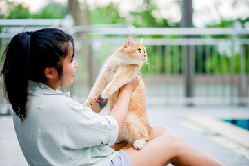 Woman holding cat playing at home with love for cats The smile glints in his bond with his fluffy pet cat. The relationship of people and cats, cat owners, domestic cats, fat cats