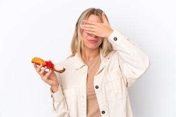 Young caucasian woman holding sashimi isolated on white background covering eyes by hands. Do not...