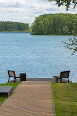 Benches for relaxing on the shore of the pond on a summer day