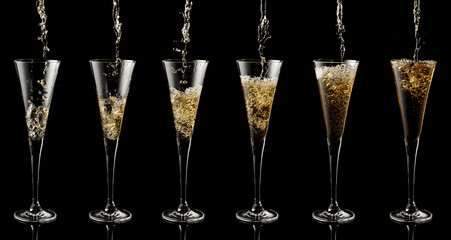 Pouring sparkling wine into a glass on a black background.