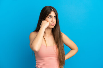 Young caucasian woman isolated on blue background with tired and bored expression