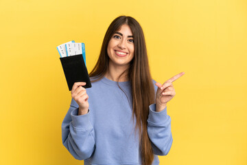 Young caucasian woman holding a passport isolated on yellow background pointing to the side to present a product