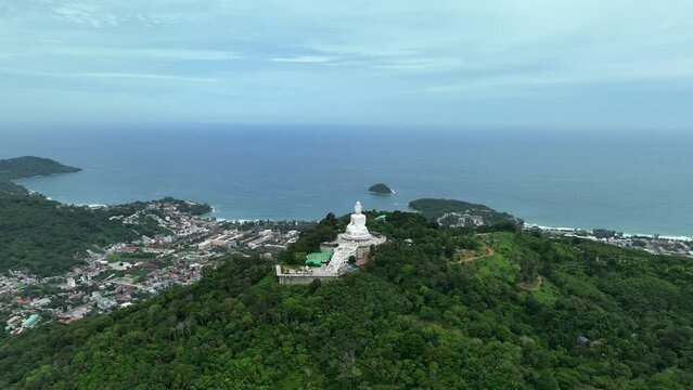 Big Buddha in Phuket, Thailand on green mountain overlooking Karon Beach, Patong and Chalong (Aerial 4K drone hyperlapse)