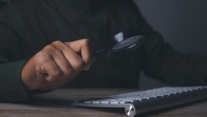 Man using magnifying glass searching data Search Engine Optimization(SEO).