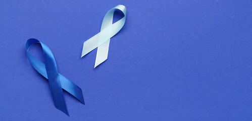 Awareness ribbons on blue background with space for text. Concept of colon and prostate cancer