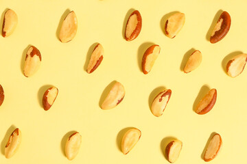 Composition with tasty Brazil nuts on yellow background