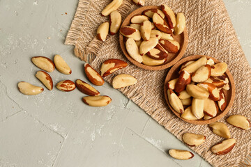 Plates of tasty Brazil nuts on light background