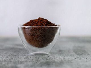 Ground coffee in a transparent glass bowl with copy space.