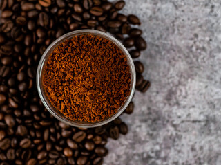 Top closeup shot of coffee powder with defocused coffee beans.