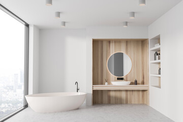 Naklejka na ściany i meble White and wooden bathroom interior with tub, sink and round mirror