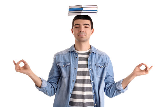 Young man with books meditating on white background. Balance concept