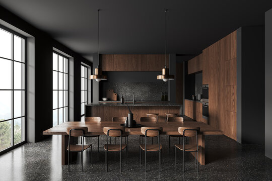 Dark kitchen interior with eating table, bar island and cooking space, window