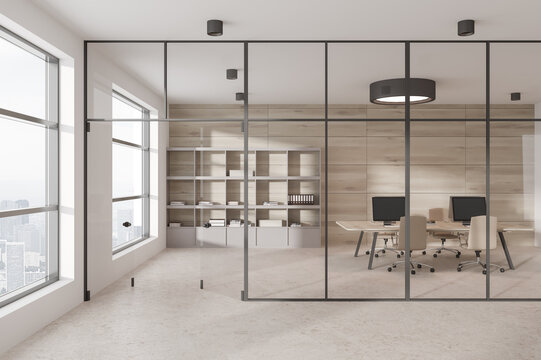 Stylish Coworking Interior With Armchairs And Pc Computer Behind Glass Doors, Desk And Minimalist Shelf On Beige Concrete Floor. Panoramic Window On Skyscrapers. 3D Rendering