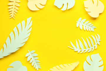 Fototapeta na wymiar Frame made of paper tropical leaves on yellow background