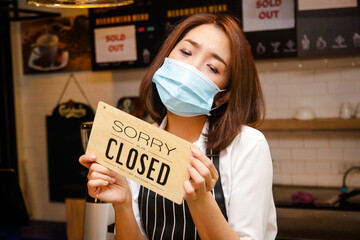 Asian women Running a coffee shop business, she wears a mask and holds a closed shop sign. Food...