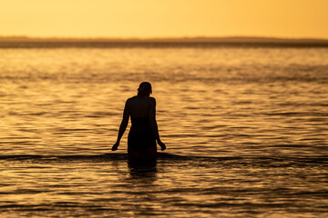 Silhouette of female swimmer going into the Atlantic ocean in Ireland