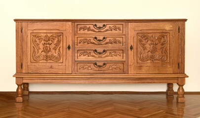 Vintage dresser in the living room on the parquet floor at home. Old-fashioned home style interior. 