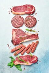 Meat background. Steaks, kebabs, cutlets and veal. Meat products. On a gray stone background. Top...