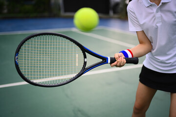Shot of tennis player hitting ball with racket to return ball over net. Sport, fitness, training and active life concept