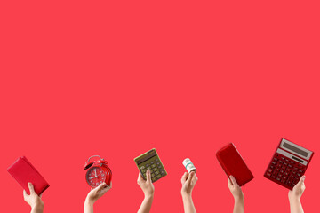 Women with money, wallets, alarm clock and calculators on red background